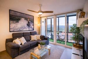a living room with a couch and a large window at Nova MSuites Xove in Lago
