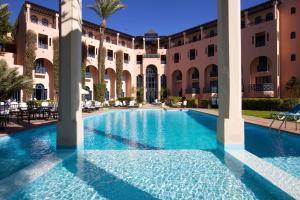 
a large swimming pool in a large city at Hotel Marrakech le Tichka in Marrakesh
