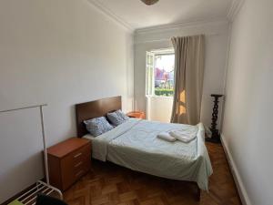 a small bedroom with a bed and a window at ICOSIUM Hostel in Braga