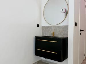 a bathroom with a black sink and a mirror at Salt Spa de Panne center in De Panne