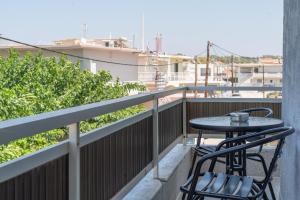 a balcony with two chairs and a table on it at House of Helios in Pastida