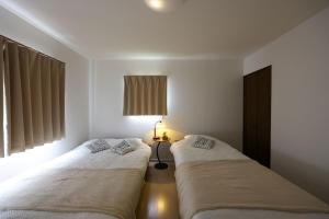 two beds sitting next to each other in a bedroom at Nagoya Kuwana Choco House in Yatomi 