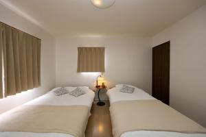 two beds sitting next to each other in a room at Nagoya Kuwana Choco House in Yatomi 