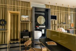 a living room with a table and a room with a tub at The Dean Munich, Autograph Collection in Munich