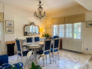 a dining room with a table and chairs and a chandelier at Villa Eleni in Lagonissi