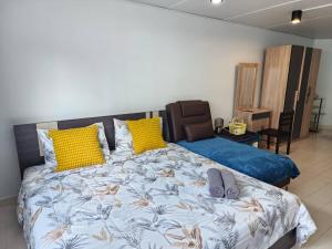 a bedroom with a large bed with yellow and blue pillows at Lovely Impact C3-C9 Lily in Nonthaburi +2 photos