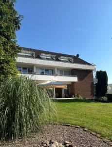 ein großes Gebäude mit einem grasbewachsenen Hof davor in der Unterkunft Hotel Bevertal in Beverungen