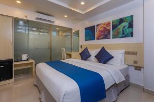 a bedroom with a large bed and a tv at White Harp Beach in Hulhumale