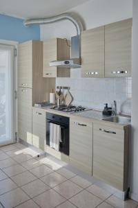 a kitchen with wooden cabinets and a stove top oven at Beach 300m Piazza Milano in Lido di Jesolo