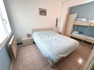 a bedroom with a bed and two bunk beds at Beach 300m Piazza Milano in Lido di Jesolo
