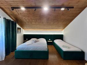 a bedroom with two beds and a wooden ceiling at Lakeview Escape Koman in Koman