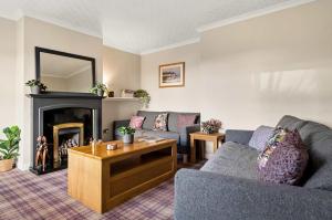 a living room with a couch and a fireplace at 4-Bed Home Central Location & Garden in Oban