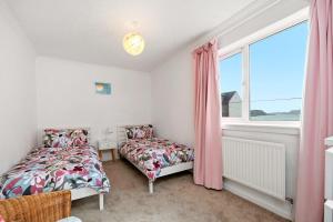 a bedroom with two beds and a window at 4-Bed Home Central Location & Garden in Oban +19 photos