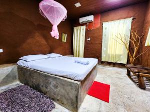 a bedroom with a bed with a pink balloon at Clay Hut by Ever Green Eco Resort in Wilpattu