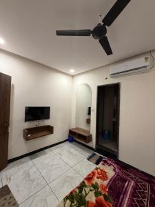 a living room with a ceiling fan and a television at Hotel Jaya shree in Ujjain