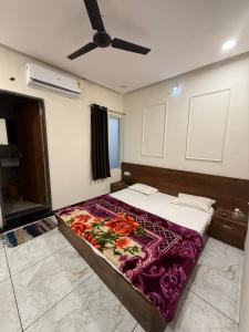 a bed in a room with a ceiling fan at Hotel Jaya shree in Ujjain