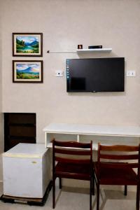 a living room with two chairs and a flat screen tv at Zolaria Hotel and Restaurant in Tagaytay
