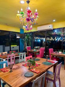 a dining room with a large wooden table with a chandelier at Zolaria Hotel and Restaurant in Tagaytay