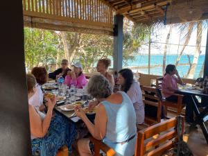 a group of people sitting around a table at a restaurant at Amurasan beach studio in Tangalle