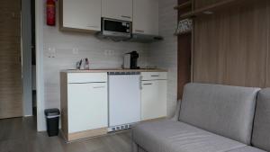 a living room with a couch and a kitchen at Nieuw Strand in Petten