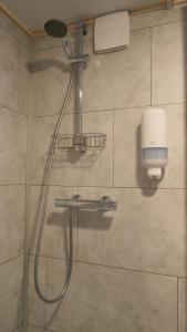 a shower with a shower head in a bathroom at Nieuw Strand in Petten +14 photos