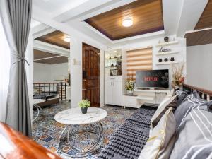 a living room with a couch and a tv at Bella Casa (3BR House at Azienda Genova) in Talisay