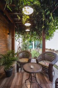 a patio with three wicker chairs and a table at Sobrado Jardim Real in Maringá