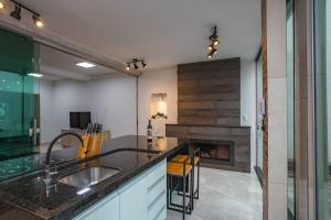 a kitchen with a sink and a fireplace at Sobrado Jardim Real in Maringá