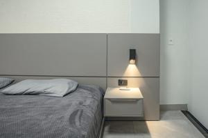 a bedroom with a bed and a nightstand with a lamp at Sobrado Jardim Real in Maringá