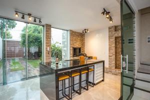a kitchen with glass walls and a large window at Sobrado Jardim Real in Maringá