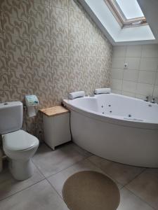 a bathroom with a white tub and a toilet at Apartamentai Rimkuose in Klaipėda