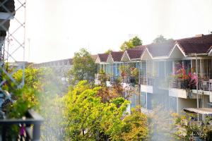 a row of apartment buildings with balconies and trees at An Nhiên House in Kon Rung (1)