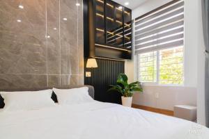 a bedroom with a white bed and a window at An Nhiên House in Kon Rung (1)