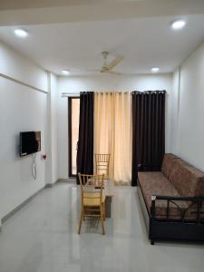 a living room with a couch and a table and chairs at Motus Mountain view Hotels in Jambhulpāda
