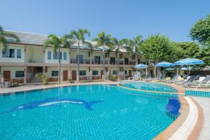 a swimming pool at a hotel with chairs and umbrellas at The Green Beach Resort in Sam Roi Yot