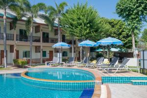 a resort pool with chairs and umbrellas at The Green Beach Resort in Sam Roi Yot