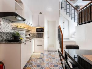 a kitchen with white cabinets and a tile floor at Bella Casa (3BR House at Azienda Genova) in Talisay +26 photos