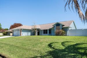 a house with a large yard with a fence at Spacious 5BR Pool Oasis Near Disney Resort in Sebastian