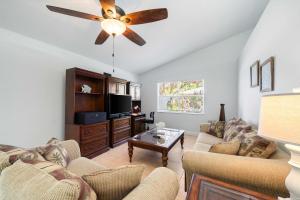 a living room with a couch and a ceiling fan at Spacious 5BR Pool Oasis Near Disney Resort in Sebastian