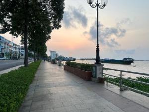 a sidewalk next to a river with a street light at La Maison de My Tho in Mỹ Tho +4 photos