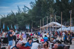 a crowd of people sitting and standing around in a park at The Green Beach Resort in Sam Roi Yot +96 photos