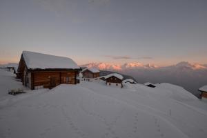 uma cabina coberta de neve no topo de uma montanha coberta de neve em Waluschi em Belalp