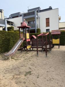 a group of playground equipment in front of a building at Apartament Gardenia Sun in Międzywodzie