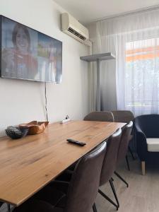 a dining room table with chairs and a television on the wall at Holiday On The Lake Lugano 5 in Bissone