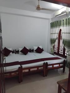 a bedroom with a bed with black and white pillows at Blue Moon Rest Inn in Trincomalee