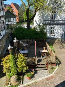 a wooden deck with tables and benches in a yard at Pension Zum Angestellten in Porta Westfalica