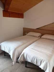 two beds sitting next to each other in a bedroom at Castle house in Aprica