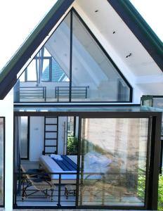 a glass house with a balcony and a table at Pini Villa in Ampara