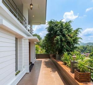 a balcony with a view of a house at Hill View Vythiri Holiday Home in Vythiri