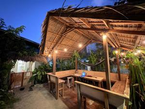 an outdoor dining area with a wooden table and umbrella at Jaydy hostel in General Luna